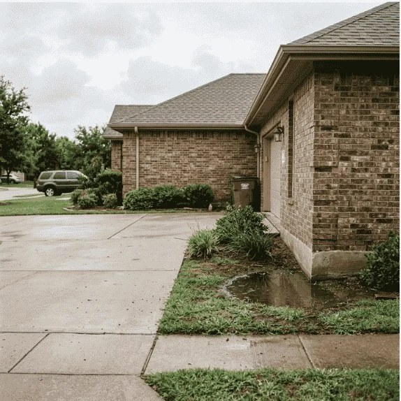 Water pooling around a home's foundation due to poor drainage in McKinney TX.
